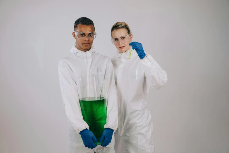 a man and woman in protective clothing holding a green liquid, pexels, antipodeans, white lab coat, nerds, tall shot, academic clothing