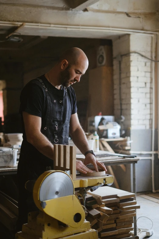 a man working on a machine in a workshop, pexels contest winner, arbeitsrat für kunst, holding wood saw, 9 9 designs, gif, portrait of small