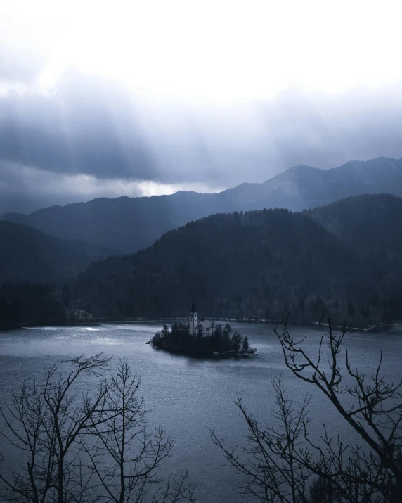 a large body of water surrounded by trees, inspired by Kaigetsudō Ando, unsplash contest winner, romanticism, dark gloomy church, sunshine lighting high mountains, slovenian, an island