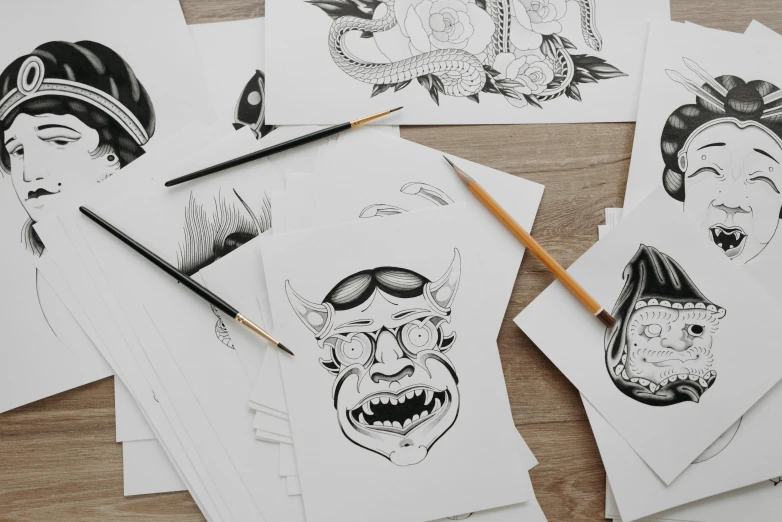a bunch of cards sitting on top of a wooden table, an ink drawing, inspired by Kawanabe Kyōsai, trending on pexels, tattoo design sketch, monster art, drawn on white parchment paper, close up portrait shot