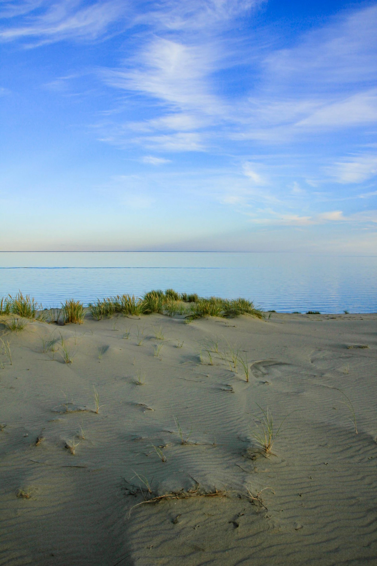 a red fire hydrant sitting on top of a sandy beach, by Jan Tengnagel, land art, sunset panorama, rostov, calm seas, dune