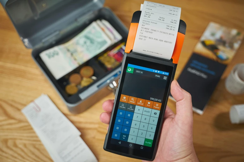 a close up of a person holding a cell phone, cash register, tripmachine, square, ergodox