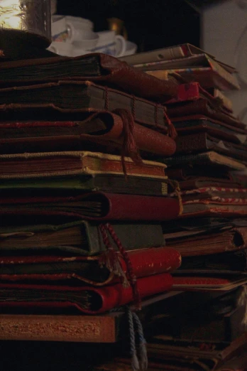 a stack of books sitting on top of a table, an album cover, unsplash, arte povera, gothic epic library, still from the film, poor quality, [ cinematic