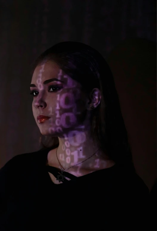 a woman standing in front of a computer screen, by Gina Pellón, holography, wearing goth makeup, glowing digital runes, profile image, hailee steinfeld