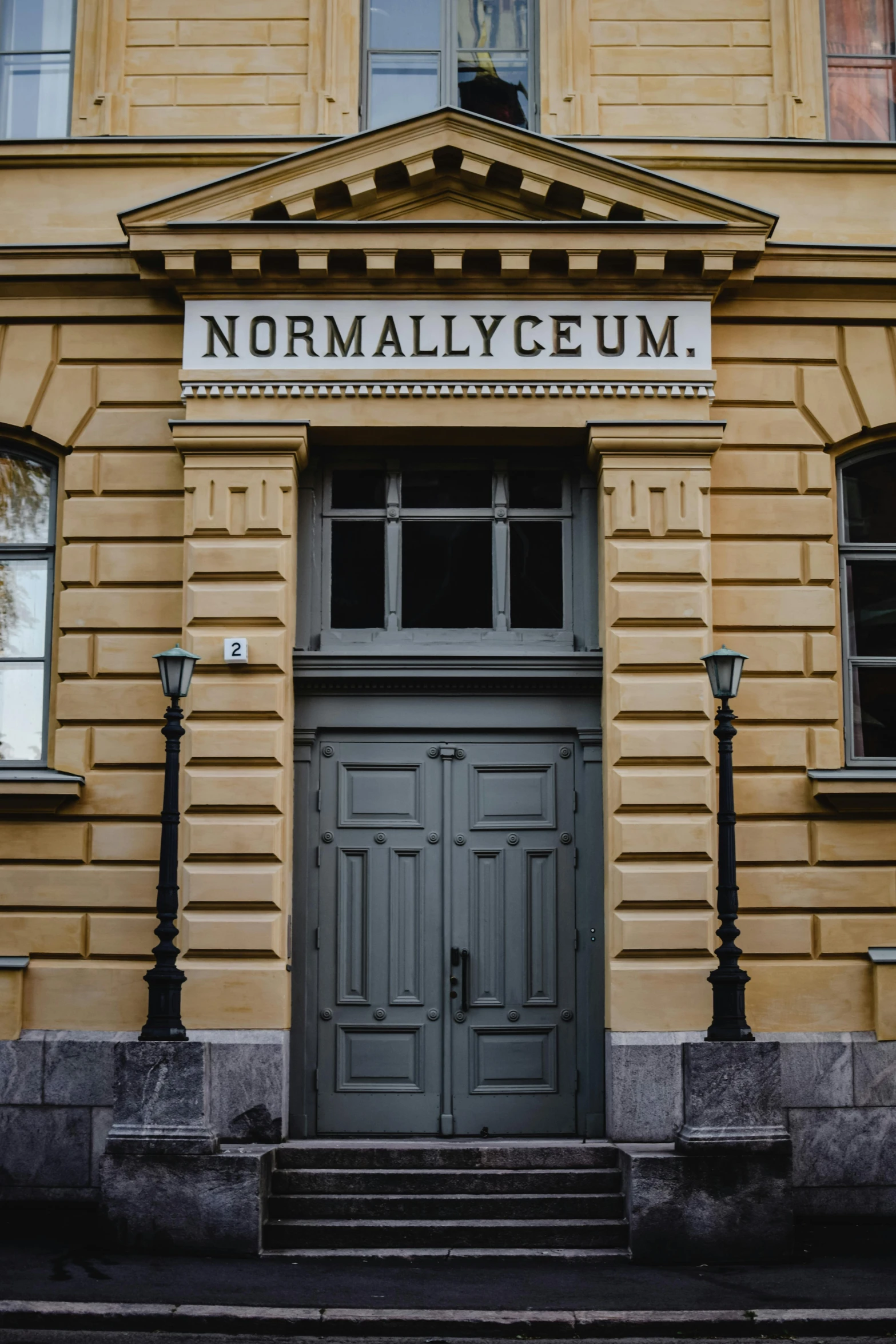 a building with a sign on the front of it, by Adam Marczyński, art nouveau, norwegian, tall entry, nuri iyem, filled with natural light