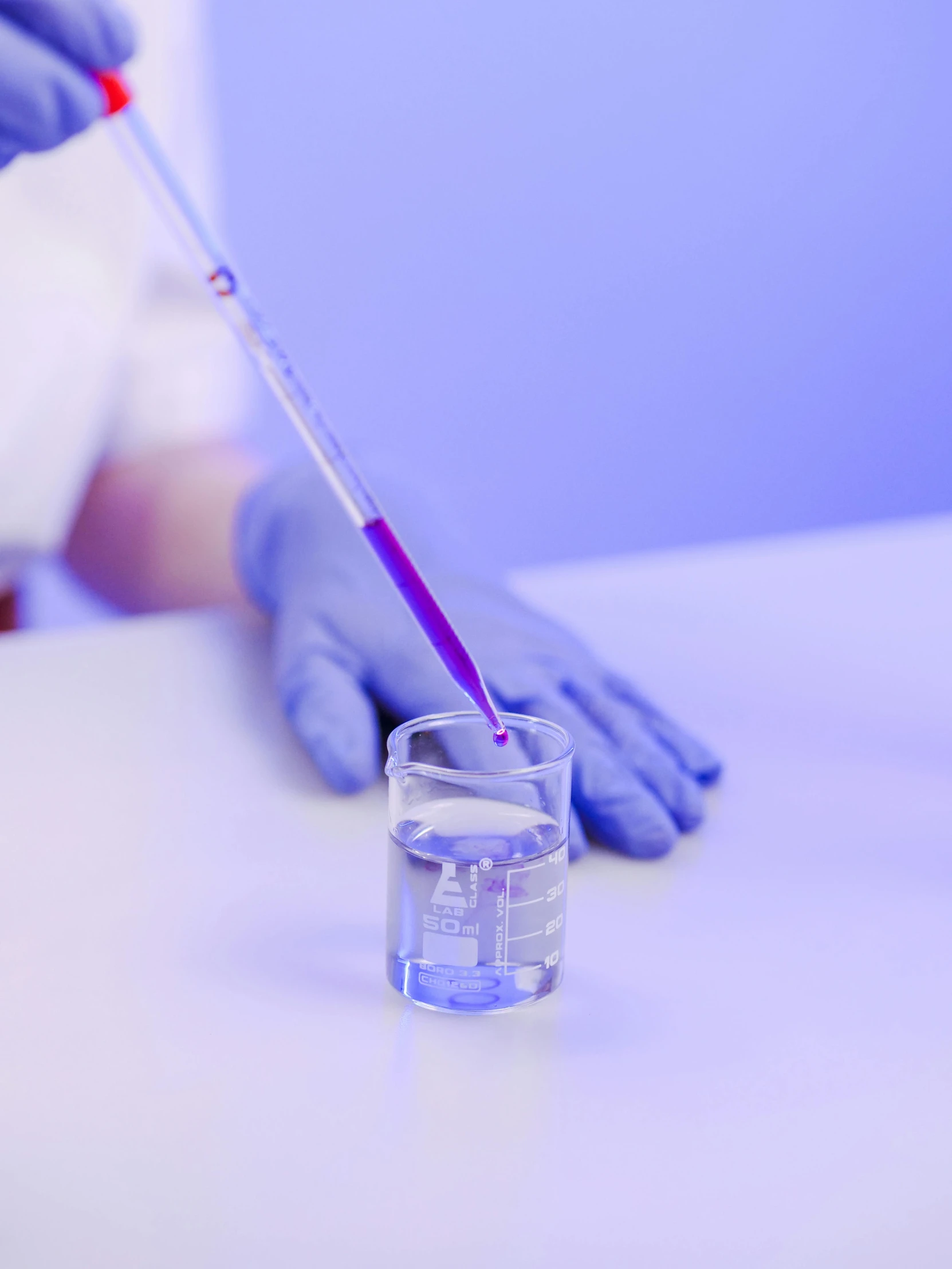 a gloved hand holding a glass filled with liquid, inspired by Yves Klein, unsplash, process art, ((purple)), surgical supplies, background image, video footage