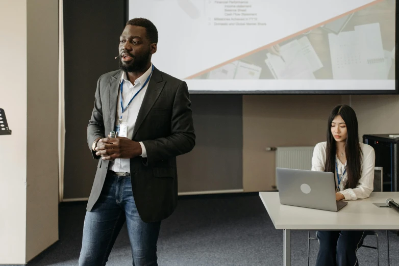 a man giving a presentation to a group of people, by Jaakko Mattila, pexels contest winner, afro tech, medium shot of two characters, looking towards the camera, promotional image