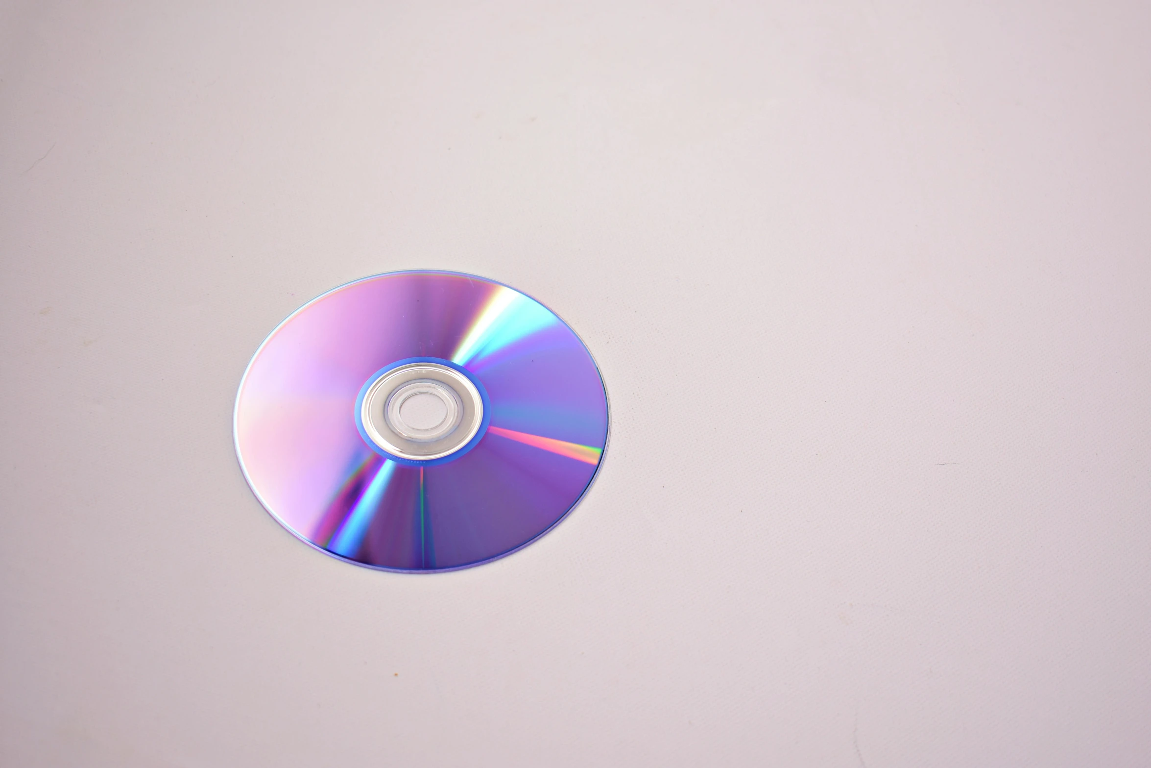 a cd sitting on top of a white surface, 15081959 21121991 01012000 4k, real photograph, blueray, small