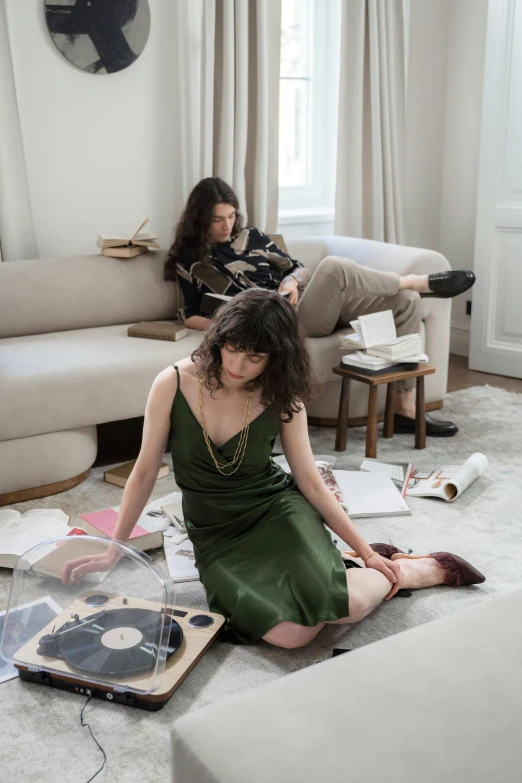 a woman sitting on the floor in a living room, an album cover, by Caro Niederer, portrait of two people, curated collections, brunettes, dezeen