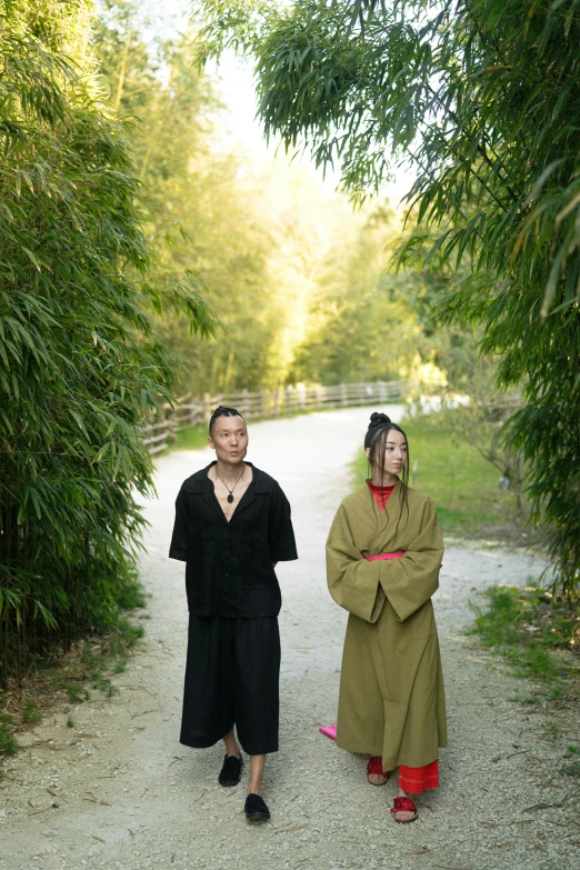 a couple of people that are walking down a path, a portrait, inspired by Tani Bunchō, renaissance, production photo, bamboo forest in the background, black robes, ( ( theatrical ) )