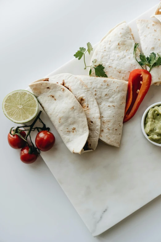 a white plate topped with tortillas and guacamole, by Carey Morris, pexels contest winner, dau-al-set, on grey background, kano), product image, wrapped