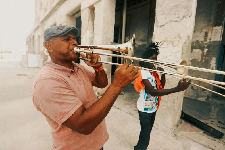 a man playing a trombone in front of a building, 💣 💥💣 💥, two horns on the head, cuba, promotional image