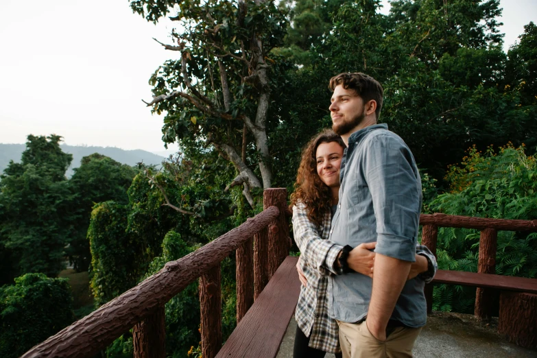 a man and woman standing next to each other on a balcony, pexels contest winner, lush forest in background, hugging, malaysian, profile image