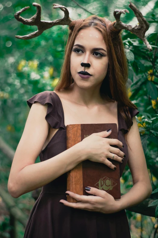 a woman with antlers on her head holding a book, inspired by Samuel Hieronymus Grimm, unsplash, portrait of a werewolf, <wearing brown leather armor>, anna nikonova aka newmilky, medium