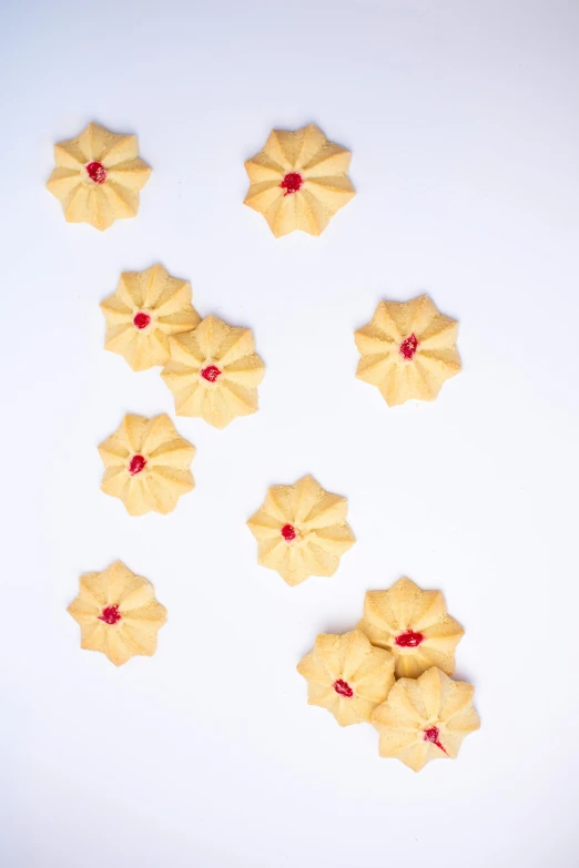 a bunch of cookies sitting on top of a table, tiny crimson petals falling, symmetrical front view, hasselblatt, medium-shot