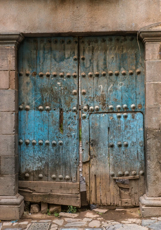 a blue door sitting on the side of a building, an album cover, by Juan Giménez, unsplash, renaissance, square, cairo, rustic, 1450