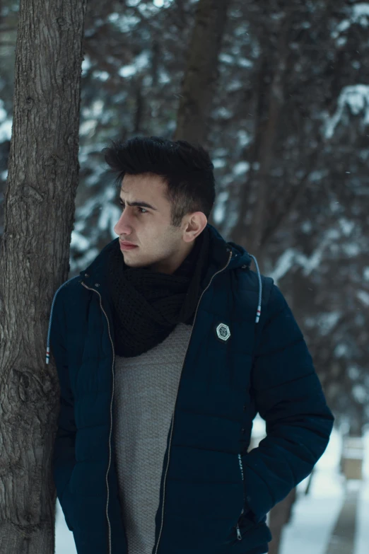 a man standing next to a tree in the snow, an album cover, inspired by Ismail Acar, pexels contest winner, handsome young man, film movie still, profile pic, young male