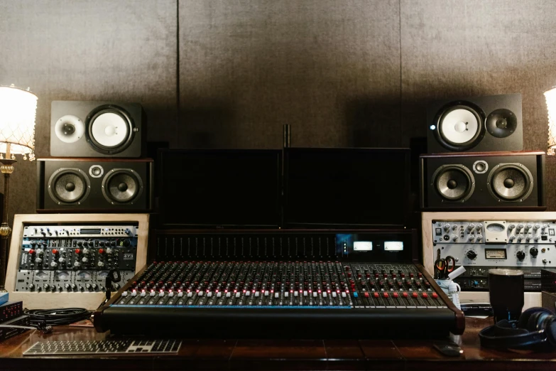 a sound board sitting on top of a wooden table, by Everett Warner, unsplash, inside a grand studio, monitors, tannoy, icon