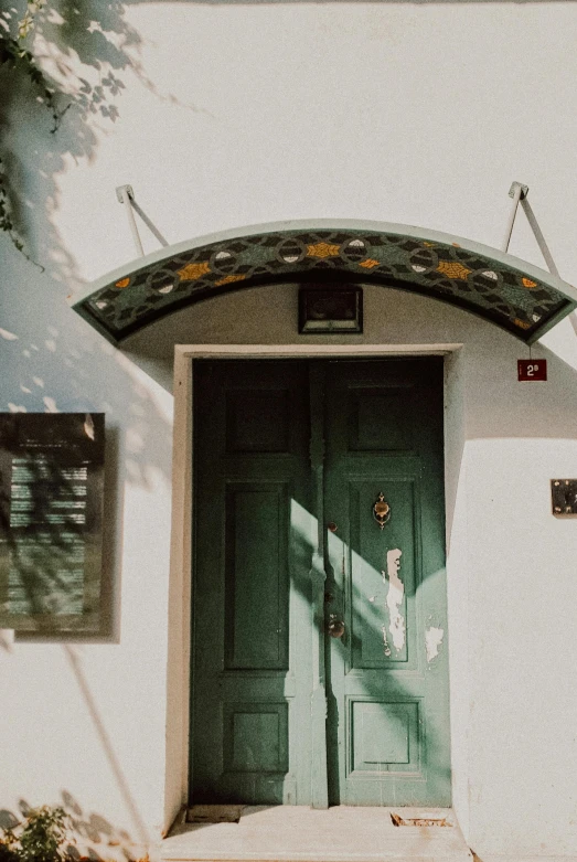 a green door sitting on the side of a white building, pexels contest winner, arts and crafts movement, marbella, banner, arched ceiling, profile image