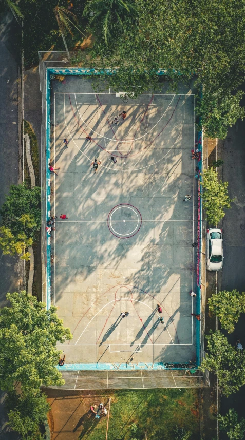 an aerial view of a basketball court surrounded by trees, an album cover, unsplash contest winner, cars and people, 15081959 21121991 01012000 4k, in sao paulo, kids playing