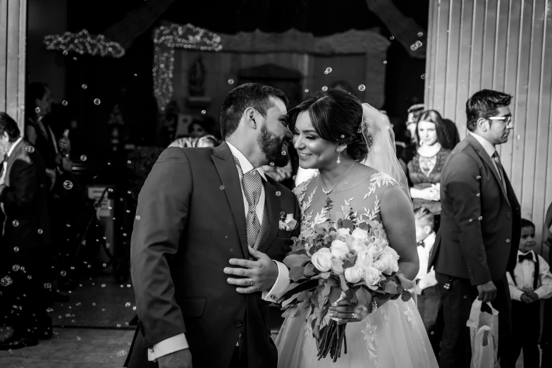 a black and white photo of a bride and groom, alanis guillen, shining and happy atmosphere, * colour splash *, bouquet