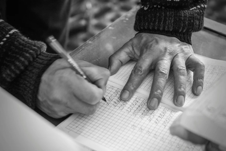 a close up of a person writing on a piece of paper, a black and white photo, by Romain brook, old man doing hard work, diary on her hand, 15081959 21121991 01012000 4k
