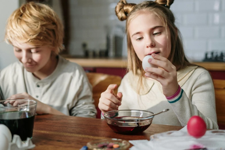 a couple of kids that are sitting at a table, pexels, eggs, essence, having a snack, teenage girl