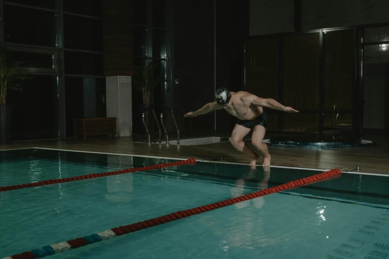 a man jumping off the edge of a swimming pool, indoor picture, cinematography photo, thumbnail, low light cinematic