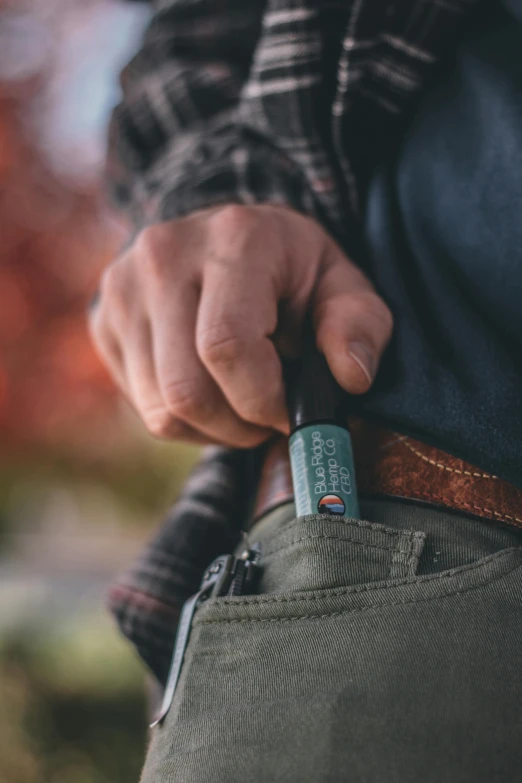 a man holding a lighter in his pocket, unsplash, carrying survival gear, detailed product image, bottom shot, full colors