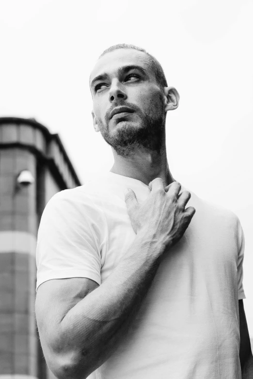 a man standing in front of a tall building, a black and white photo, antipodeans, pitbull, liam brazier and nielly, portait image, hairless