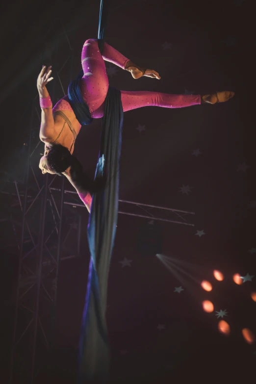 a woman flying through the air on top of a pole, arabesque, draped in purple and gold silk, event photography, high view, official screenshot