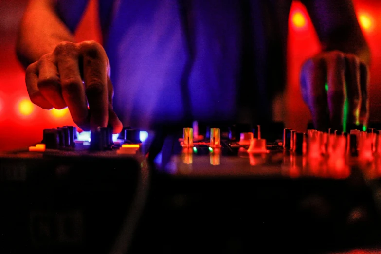 a close up of a person using a dj controller, by Niko Henrichon, taken in night club, dsrl photo