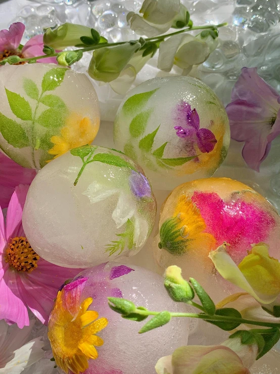 a bowl filled with ice and flowers on top of a table, energy spheres, medium closeup, various sizes, cheery