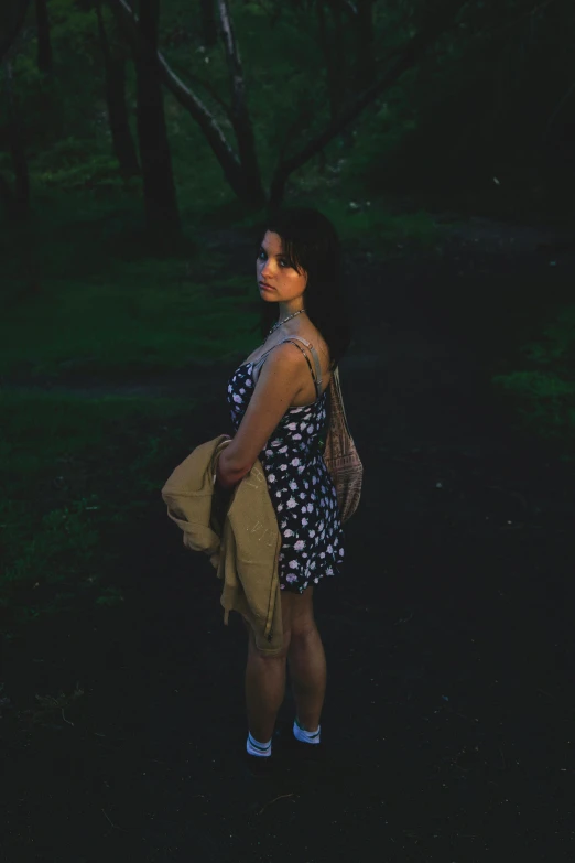 a woman standing on a path in a park, inspired by Elsa Bleda, low - lighting, ((portrait)), low quality photo, pose 4 of 1 6