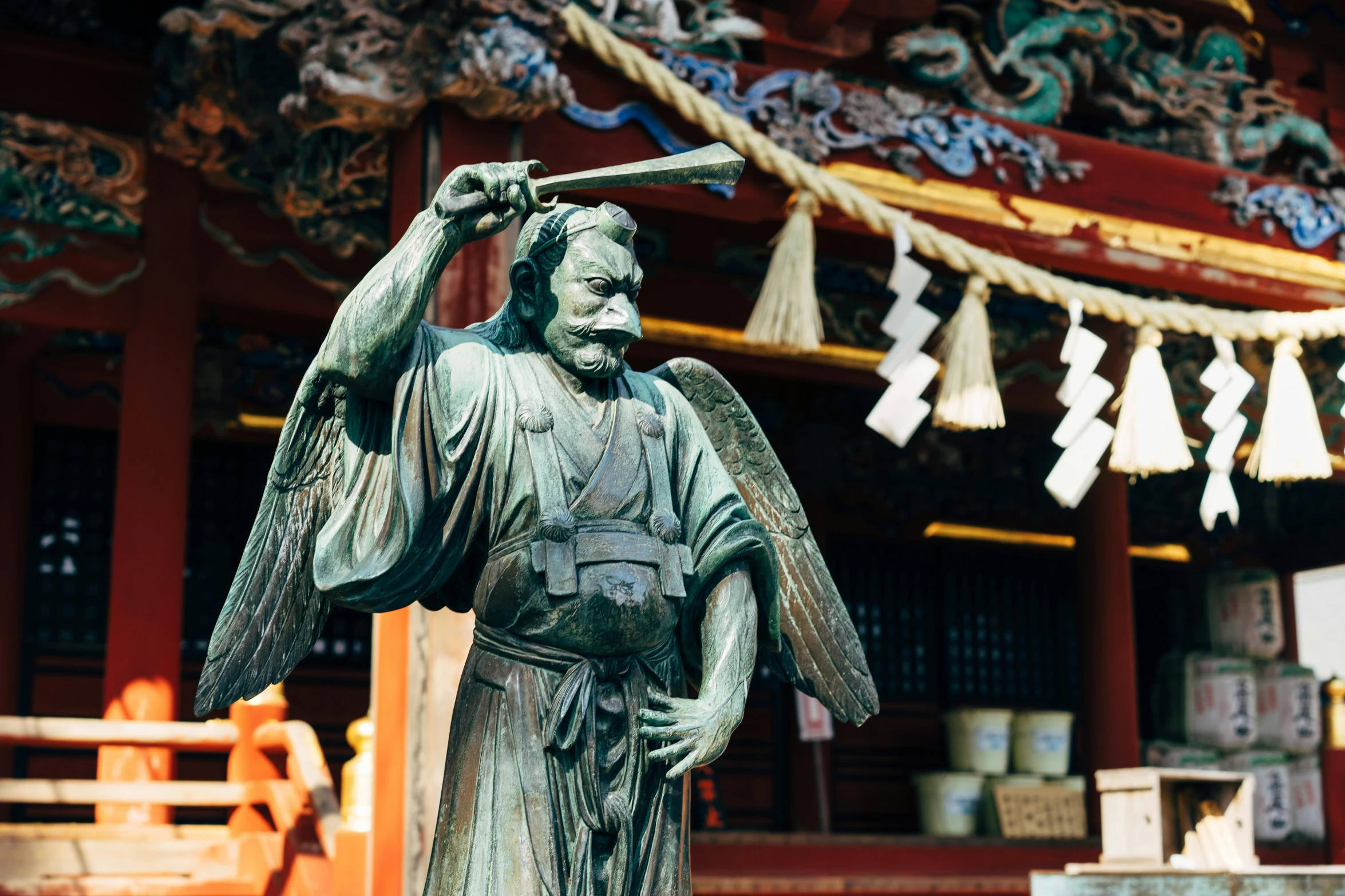 a statue of an angel in front of a building, a statue, inspired by Itō Jakuchū, pexels contest winner, sōsaku hanga, holding scale and holding sword, standing in a buddhist temple, fujifilm”