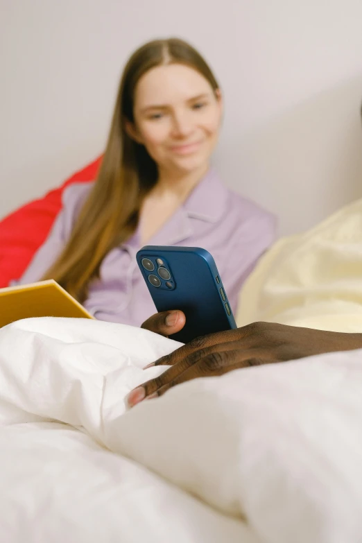 a woman sitting on top of a bed next to a man, trending on pexels, happening, sony nicon iphone 1 3 pro max, detail shot, reading, connectivity