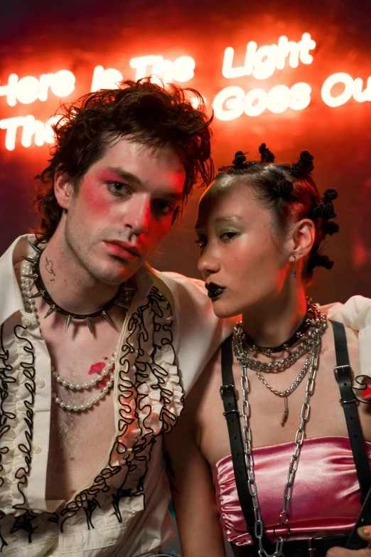 a man and a woman standing next to each other, inspired by Nan Goldin, international gothic, wearing a bandana and chain, pigtails, elaborate hair worn up, sideburns