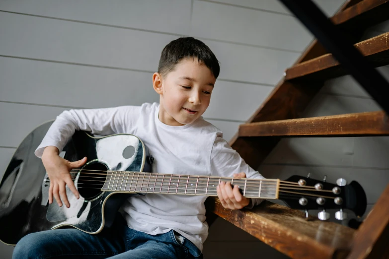 a little boy that is sitting down with a guitar, pexels contest winner, looking across the shoulder, 15081959 21121991 01012000 4k, instagram post, educational