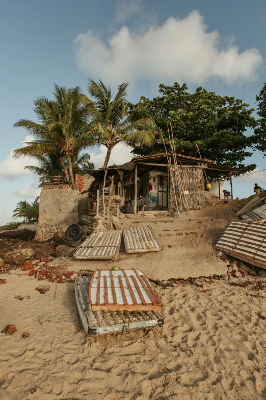 a group of beds sitting on top of a sandy beach, wrecked buildings, caio santos, wētā fx, tropical location