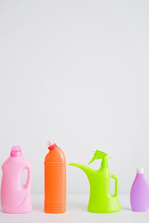 a group of different colored plastic bottles next to each other, detailed product image, spraying liquid, pink and orange, portrait image