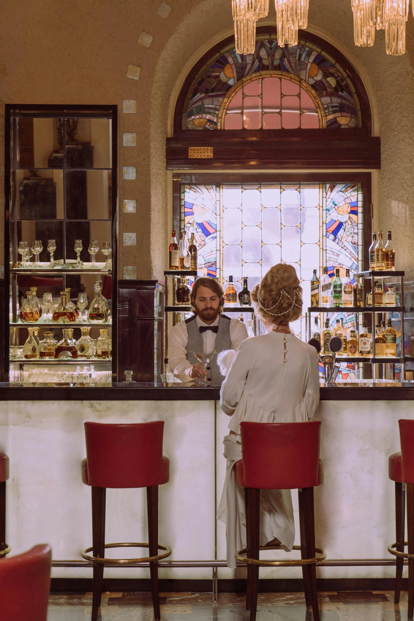 a couple of people that are sitting at a bar, inspired by Tomàs Barceló, art nouveau, cinematic wide shot, at checkout, classic cinema, brown
