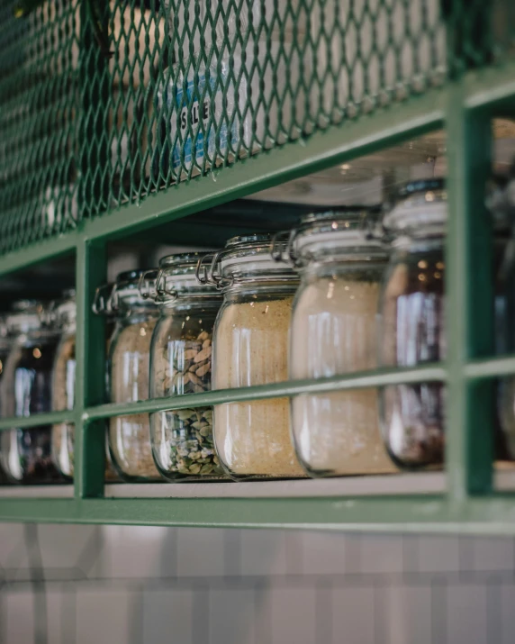 a bunch of jars that are on a shelf, trending on unsplash, restaurant menu photo, steel window mullions, yellow and green scheme, close up shot from the side