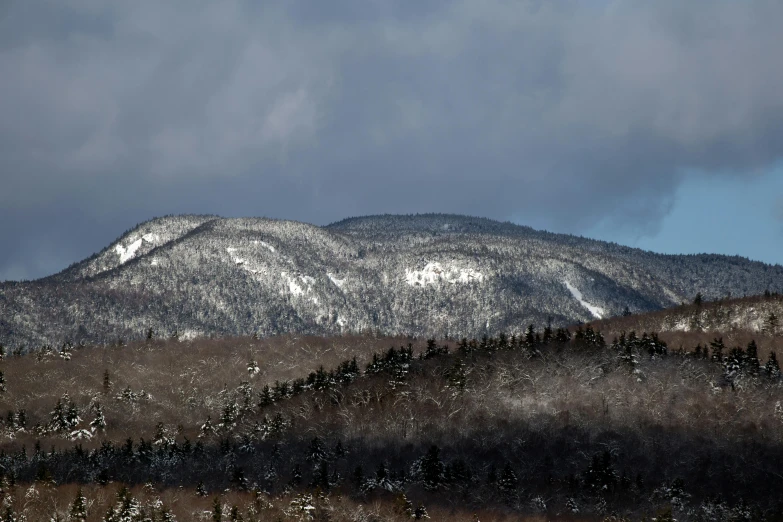 a man riding a snowboard down a snow covered slope, pexels contest winner, hudson river school, view of forest, new hampshire mountain, seen from a distance, today\'s featured photograph 4k