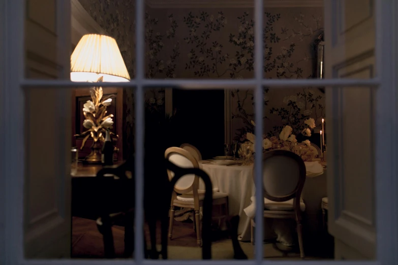 a view of a dining room through a window, inspired by Georges de La Tour, shot on hasselblad, porcelain, regency-era, lamplight