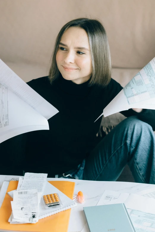 a woman sitting on a couch holding papers, happening, formulas, high budget, instagram picture, papers on table