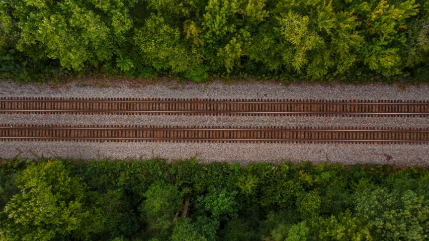 an overhead view of a train track surrounded by trees, inspired by Thomas Struth, high res 8k, fan favorite, square lines, full width