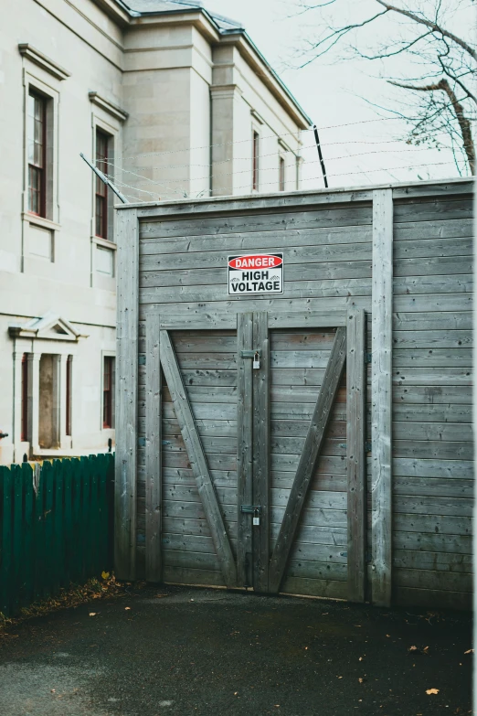a red fire hydrant sitting in front of a building, an album cover, unsplash, graffiti, wooden cottage, gray, high voltage warning sign, gate