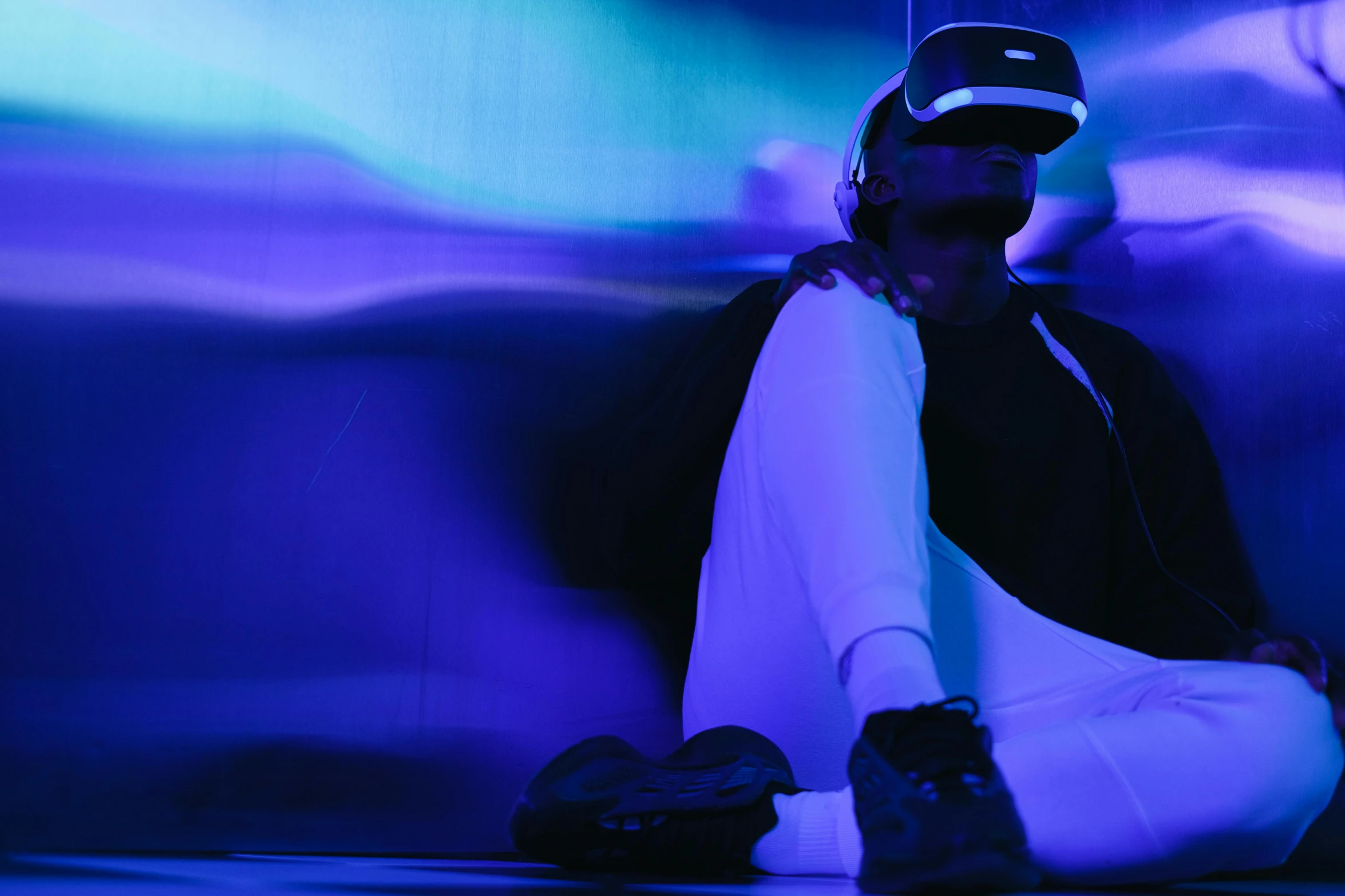 a man sitting on the ground wearing headphones, a hologram, unsplash, interactive art, sleek oled blue visor for eyes, ((raytracing)), vr game, teamlab