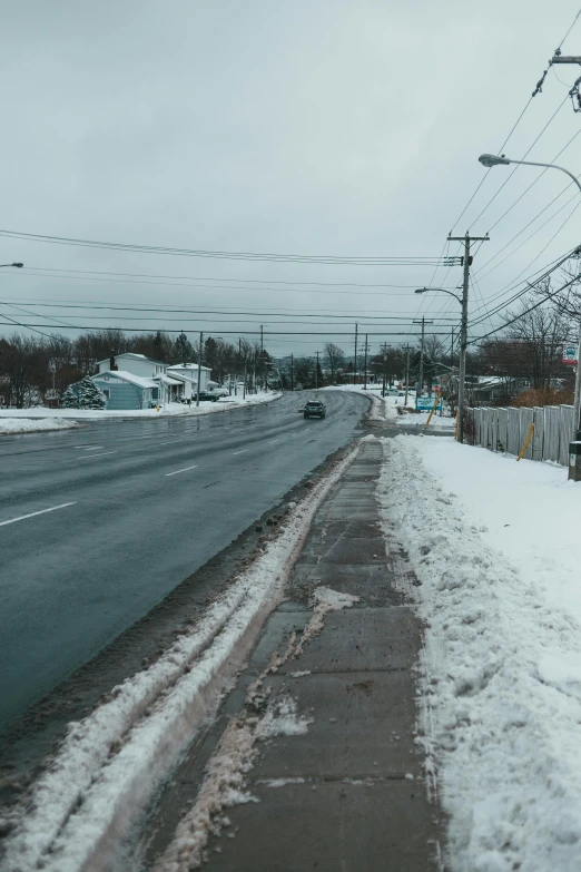 a street sign sitting on the side of a snow covered road, an album cover, by Ryan Pancoast, unsplash, walking through a suburb, panoramic shot, quebec, wet streets