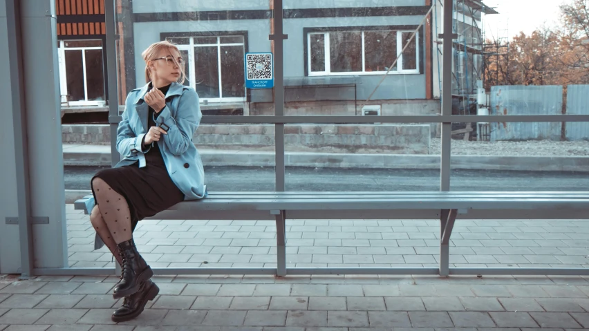 a woman sitting on a bench at a bus stop, by Emma Andijewska, pexels contest winner, pale blue outfit, soviet style cyberpunk, 15081959 21121991 01012000 4k, androgynous male